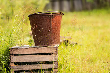Fototapeta premium an old iron bucket at wooden pallet