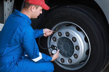 A mechanic checks the tire pressure gauge truck