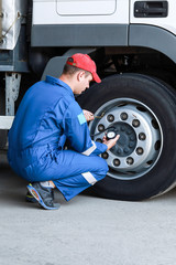 A mechanic checks the tire pressure gauge truck