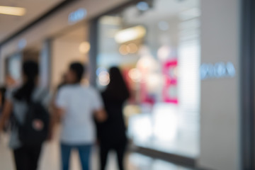 Shopping center with customers and seasonal sale promotions. Blurred, people unrecognizable