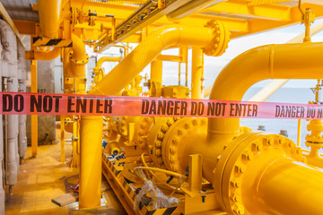 Warning label danger do not enter stick on lines of barrier tape/Hazard alert/Block location/ in sea offshore.