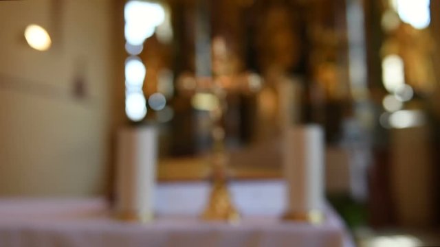 Altar in catholic church with cross and candles from blur to focus