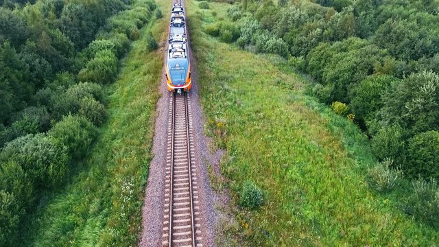 An aerial of A steam train as It passes through the Estonian countryside at hig