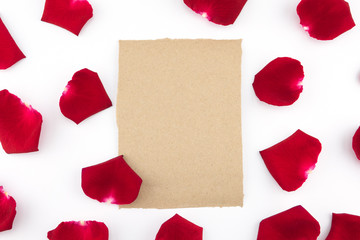 Blank brown card with red rose petals on white background