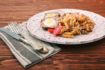 Boiled eggs in a layer of sausage meat wrapped with pasta