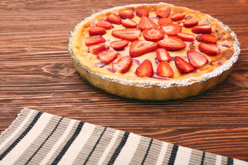 Tart with fresh strawberry on wooden background