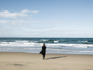 Fototapeta na wymiar A woman walking towards the sea