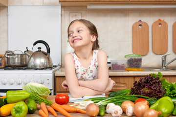 child girl with fruits and vegetables in home kitchen interior, read cooking book, healthy food concept