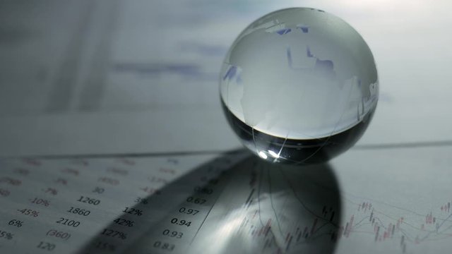 Glass of globe over stock market chart