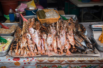 Fried fish on the food market. Different varieties of cooked fish on the counter in the open market of Kota Kinabalu. Travel Malaysia