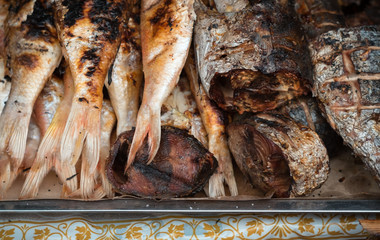 Close up fried fish on the food market. Different varieties of cooked fish on the counter in the open market of Kota Kinabalu. Travel Malaysia