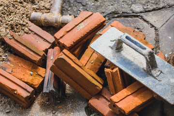 construction work of property concept. worker tools with brick in dirty workplace.