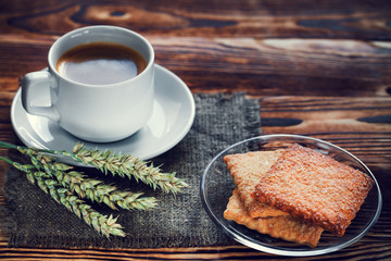 Coffee cup and cookie on wood
