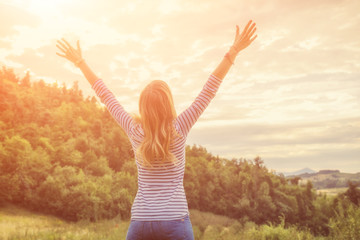 Woman enjoying in the nature with arms wide open.