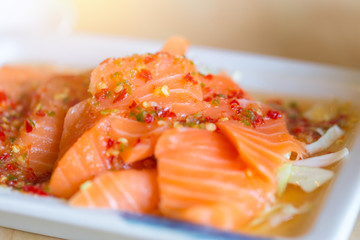 japanese fusion food. japan fresh salmon fish seafood sashimi mix with hot spicy chili sour lemon lime juice in Thai style menu.
