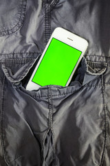 Smart phone in pants pocket with green black screen for text or picture. Concecpt for advertising, business.
