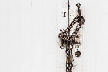 closeup white door lock old grunge chain hard locking with space for text.