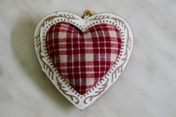 Ornamental red heart with white frame on white background, in center
