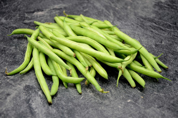 Green beans on black background close up photo
