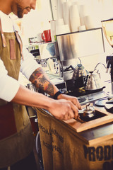 A man pouring coffee in a restaurant.