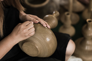 senior asian handcraft potter making clay pot earthware by hand.