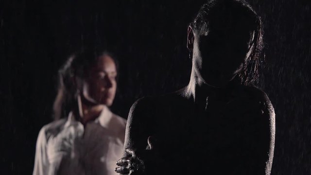 Homosexual couple, gay, young lesbians, same-sex marriage relationship between the girls. they stand at night in the dark insults at each other. the silhouettes the wet naked bodies shined by the moon