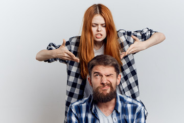 1226013 Man with a beard on a light background with a young beautiful woman, emotions