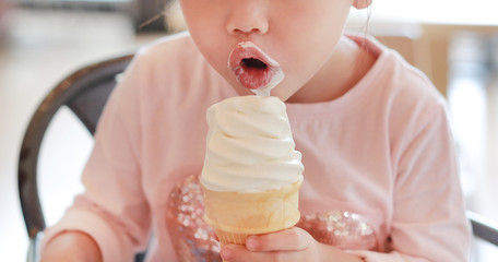 Close-up child girl eating ice cream.