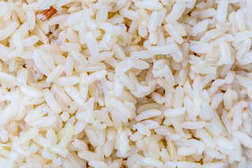 Texture detail of cooked brown rice on white background, nutrition & healthy eating concept.