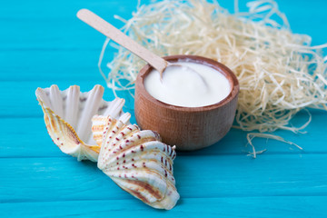 White substance in wooden cup with cinnamon and spices. For hair, face, spa.