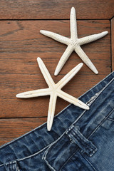 Fototapeta na wymiar jeans texture and starfish on wooden background