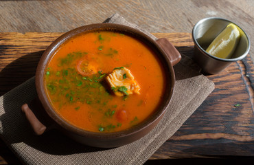 Marmitako soup in a ceramic bowl on a wooden board