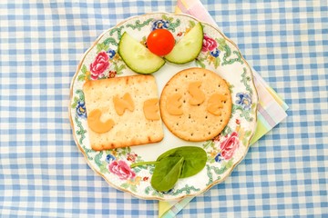 Crackers with the word cheese cut from orange cheese on a plate with a side salad