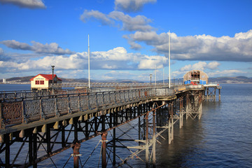 Fototapeta na wymiar Mumbles Pier in Swansea Bay which is a Victorian construction and a popular visitor attraction of the area