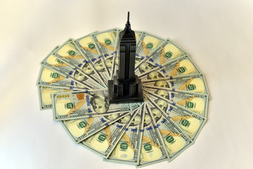 Skyscraper Figure on One Hundred Dollar bank notes circle stack and isolated on pure white background