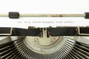 The text And they lived happily ever after, on a white paper page in an old vintage typewriter. Macro detail shot.
