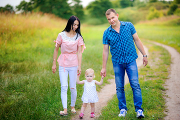 Fototapeta premium happy family walks in the park, amicably hold hands and smile