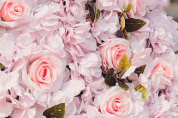 Pink fake flowers roses background. Close up, texture. Toned.