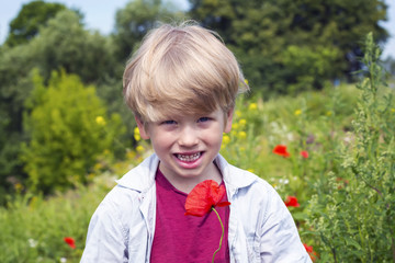 Nice blond boy with a red poppy in his hand.