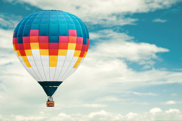 Colorful hot-air balloon against blue cloudy sky