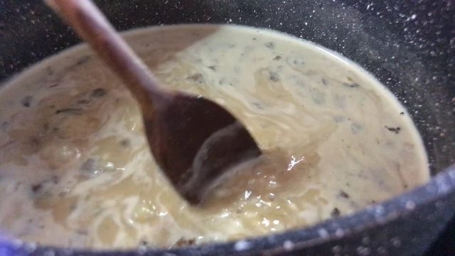 Risotto pronto viene cotto in padella con cucchiaio in legno