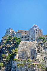 Fototapeta premium Aragonese castle on a cliff on the background of blue sky
