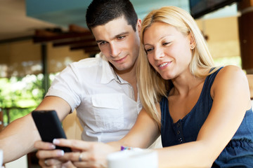 Couple reading text message on mobile phone.