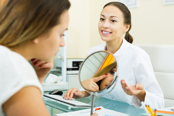 Smiling visitor listening  beautician in medicine center