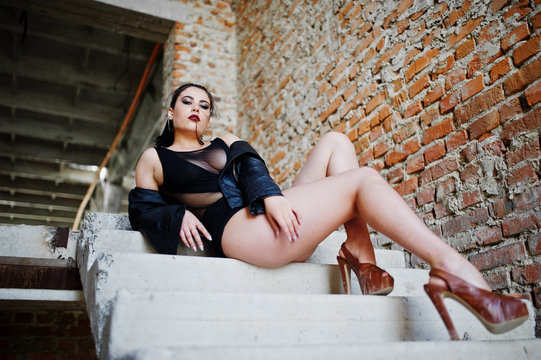 Brunette Plus Size Sexy Woman, Wear At Black One Piece And Leather Jacket, At Abadoned Place Sitting On Stairs.