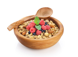 Muesli with nuts and fresh berries in a wooden bowl isolated on white background.