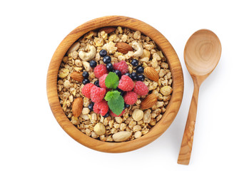 Muesli with nuts and fresh berries in a wooden bowl isolated on white background.