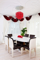 White glossy table with leather chairs in white and red classical interior