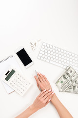 cropped shot of businesswoman working with calculator and dollar banknotes at workplace