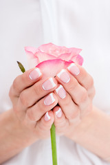 close-up partial view of young woman holding beautiful pink rose
